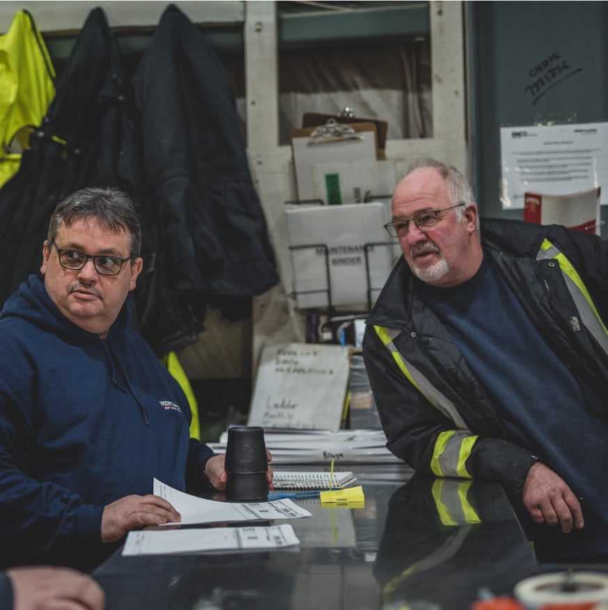 Two workers in a warehouse having a meeting.